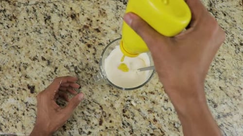 Adding Mustard to Light-Colored Sauce in a Cup