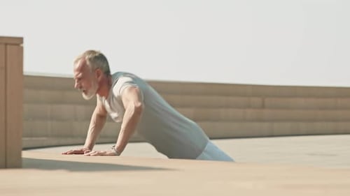 Senior Man Doing Push-Ups Outdoors in Urban Setting