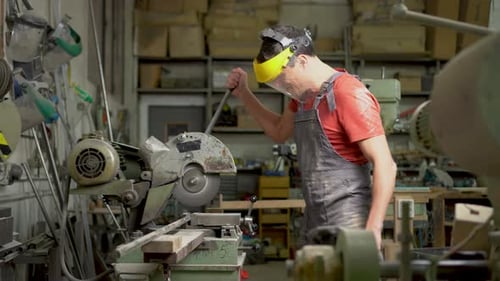 Handyman Operating Steel Cutter Machine in Workshop