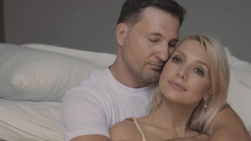 Loving Couple Embracing in a Bedroom