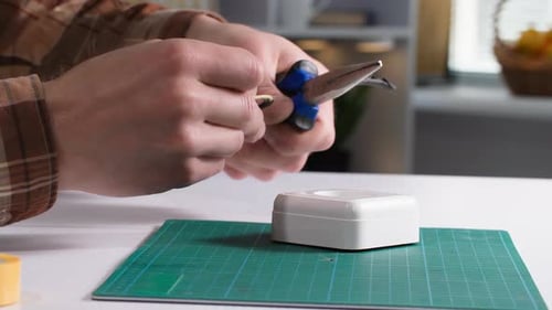 Electrician a Man Repairs an Electrical Outlet and Strips the Wires for Connection Closeup