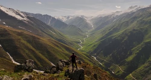 Lone Figure on Mountain Peak – Aerial Freedom Scene in Breathtaking Nature