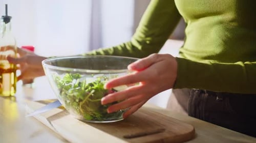 Woman Preparing Healthy Salad with Olive Oil and Spices