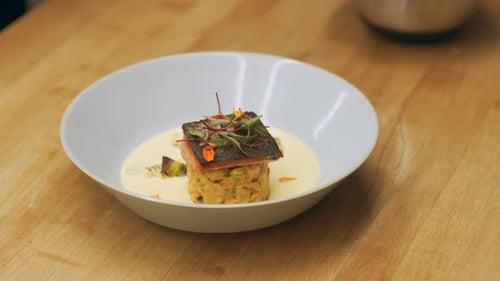 Chef plating beautiful fish dish at restaurant