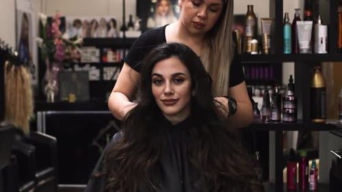 Woman Styling Long Brown Hair in Salon