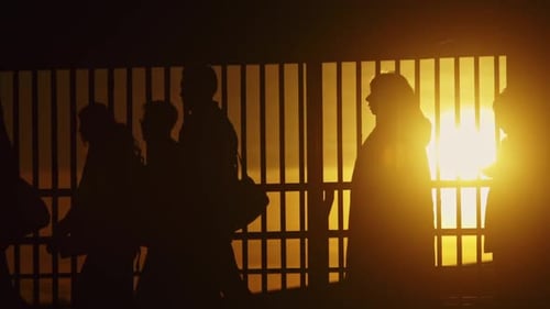 Silhouettes of People Walking Against Golden Sunset