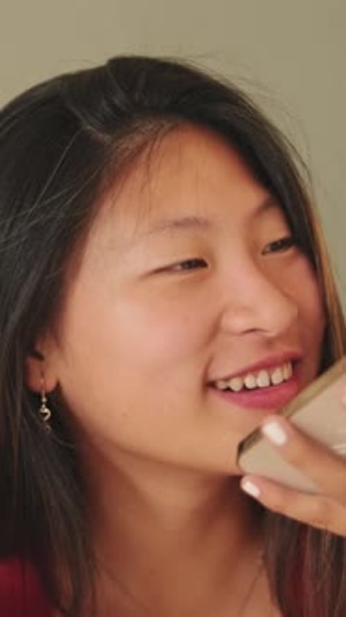 Young Woman Talking on Speakerphone Indoors