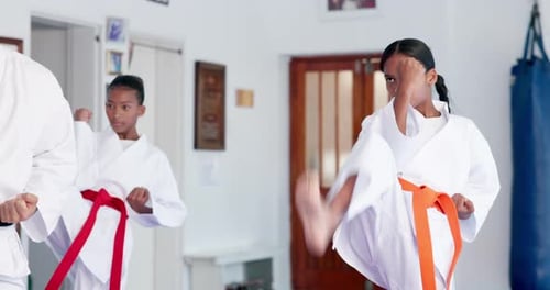 Young Girls Practice Karate Kicks and Punches Indoors