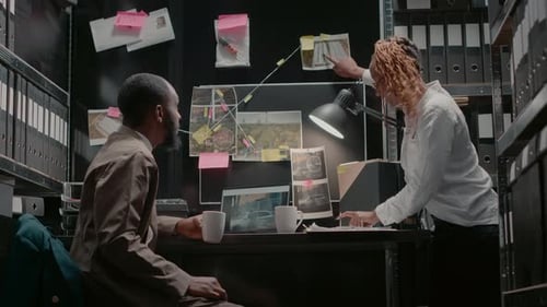 Detectives Reviewing Evidence in Dark Office