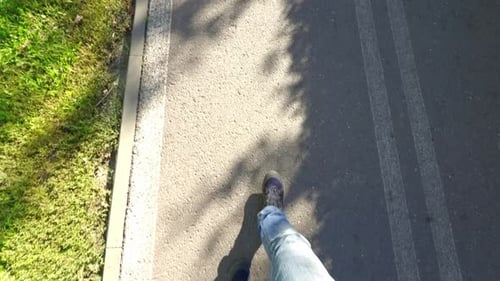 Mann läuft auf einem gepflasterten Weg in einem Park