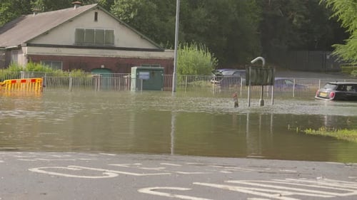 Static Shot of Flooded Roundabout with Barrier Underwater with Submerged Car After Flash Flood