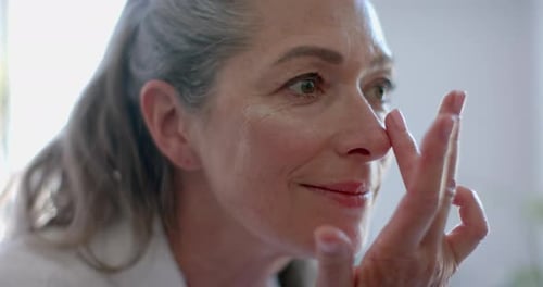 Senior Woman Applies Moisturizing Face Cream