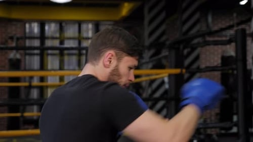 A Young Boxer Guy Trains in a Boxing Gym