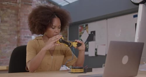 Adult Female Engineer Developing Robot Technology in Workshop