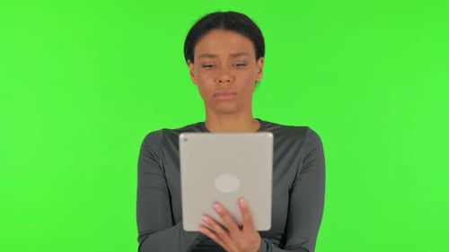 African Woman Using Digital Tablet on Green Background