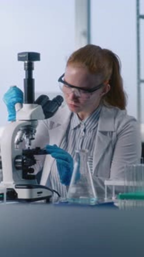 Woman Scientist Working with a Microscope in Laboratory
