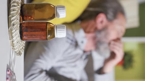 Vidéo verticale de l'homme âgé, dont la santé est critique à la maison, tousse, est essoufflé
