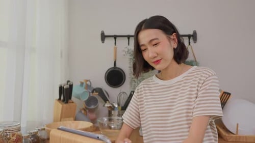 Woman Using Tablet in Bright Kitchen