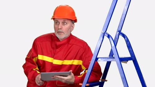 Serious Senior Male Factory or Construction Worker Using a Digital Tablet