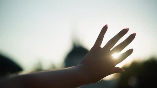 Close Up Hand Reaching Towards Sunlight Creating Interplay Between Fingers and Rays