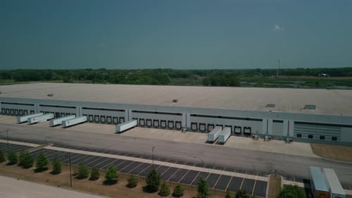 Warehouse with Semi Trucks and Cargo Trailers Aerial View