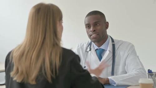 African Doctor Consulting Female Patient in Clinic