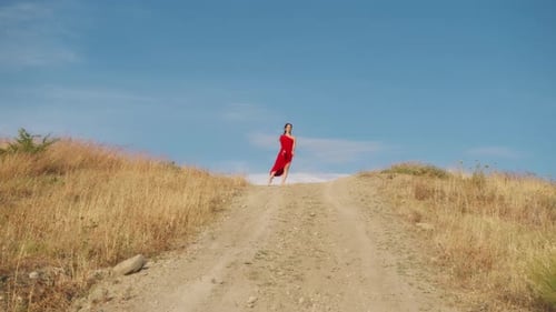 Ballerina In Red Dress Dances On A Hill In Sicily