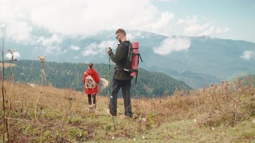 Beautiful Landscape of Highland and Two Backpackers Walking Together Early Spring in Mountains