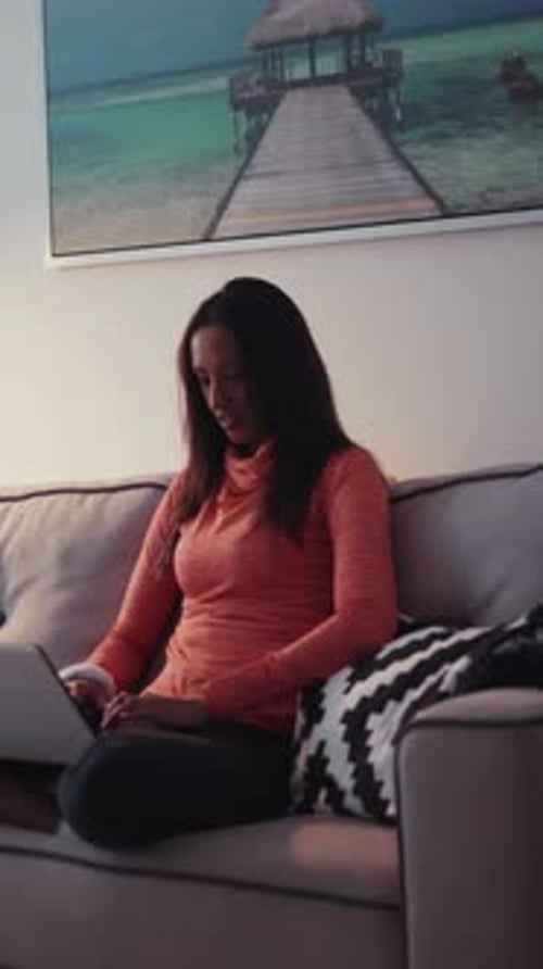 Woman Sitting on Couch Typing on Laptop