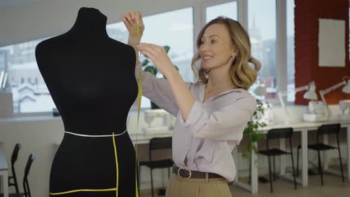 Female Tailor Measuring a Mannequin for a Custom Garment Design