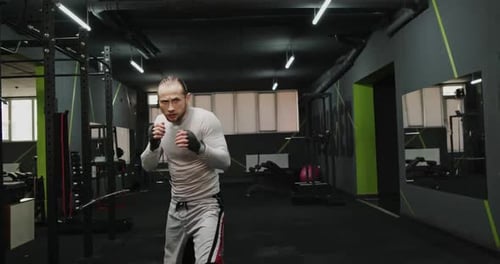 Strong Fighter Practicing Kicks in Gym