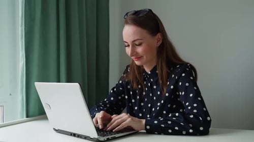 Woman Working on Laptop at Desk in Home Office