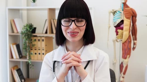 Confident Female Doctor at Office Desk Ready to Assist Patients