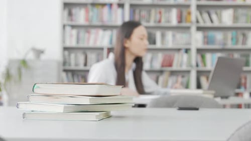 Focused Female Student Immersed in Study at a Vibrant College Library