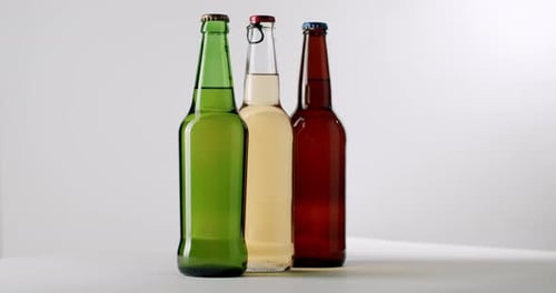 Three Different Bottles of Craft Beer Rotating