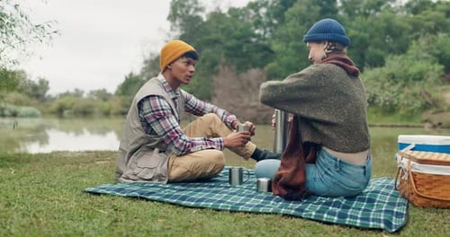 Love, coffee and couple with picnic in a forest for travel, adventure or bonding with conversation