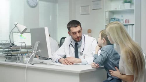Doctor Consults with Child and Mother in Clinic