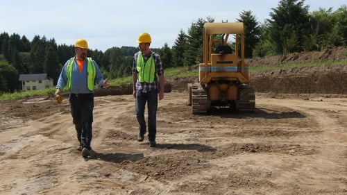 Men Walking Near Bulldozer on Construction Site