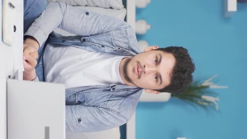 Vertical video of Man looking negative at camera.