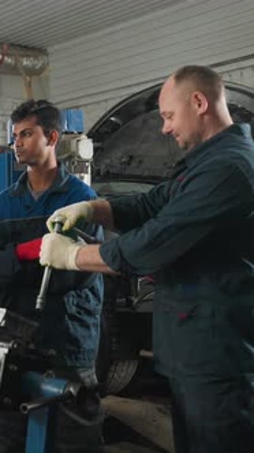 Engineer Demonstrates Bolt Loosening to Students in Automotive Workshop