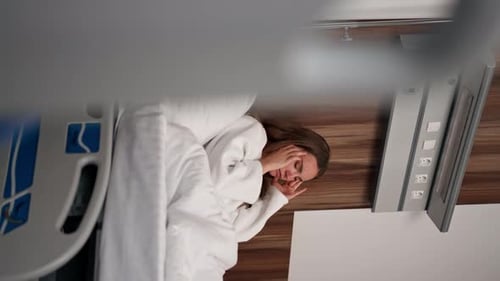 Vertical Video in Modern Clinic in a Bright VIP Room Lies Young Girl in a White Coat with a Cold