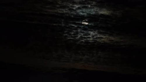 La lune se déplace derrière une étrange couverture nuageuse en un laps de temps (4k)