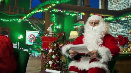 Man Dressed as Santa Reading Letter In Home