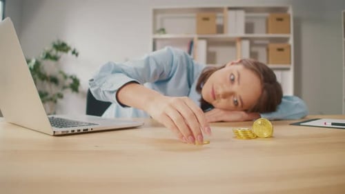 Serious Woman Freelance Plays with Gold BTC Coin at Home
