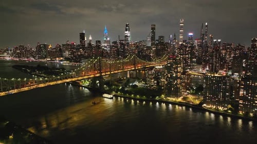 Illuminated Queensboro Bridge - New York City Skyline Glowing At Night - Drone Shot