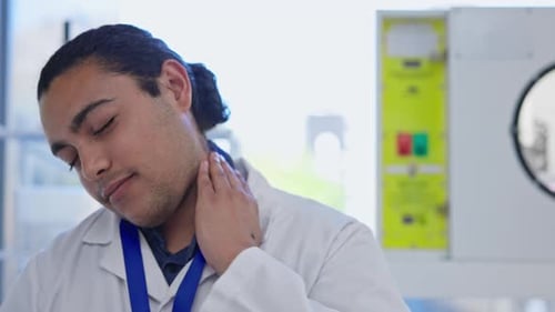Young Adult Massages Aching Neck in Lab