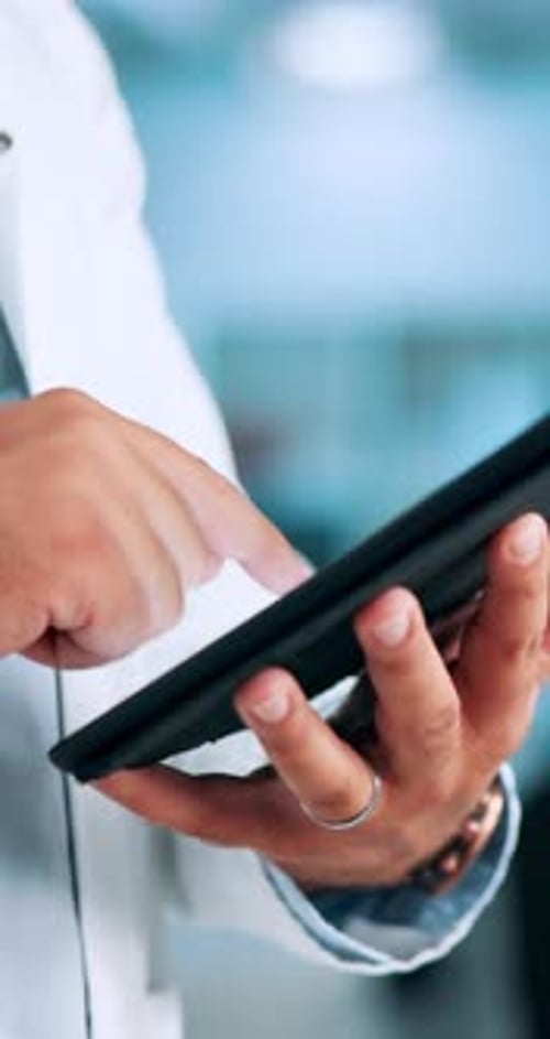 Man in White Coat Using Tablet in Hospital