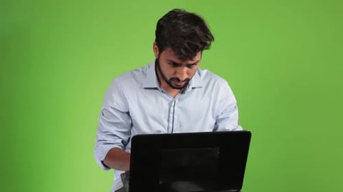Portrait of young attractive bearded man architect working at a desk, use laptop in the office green