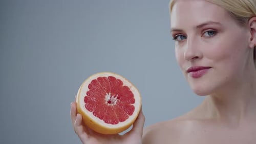 Beauty and Citrus Uma modelo cativante posando graciosamente com uma toranja vibrante