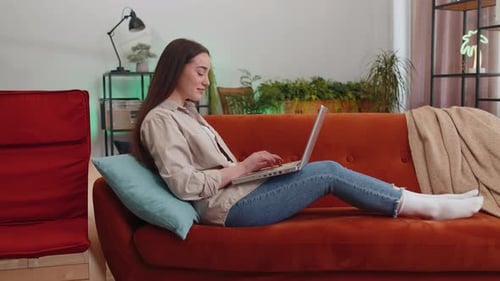 Woman Using Laptop Computer Comfortably at Home